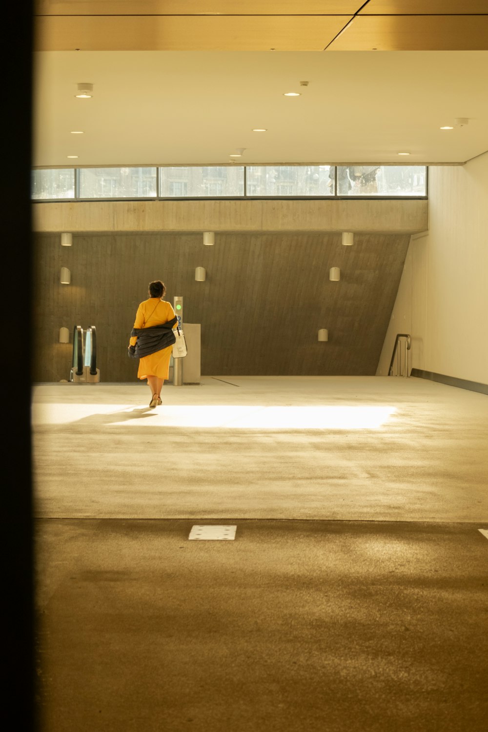 a person in a yellow jacket walking in a large room