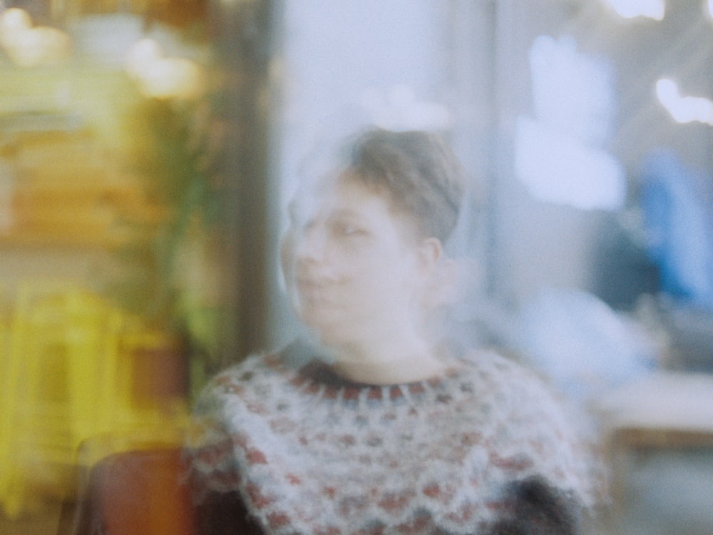 a blurry photo of a woman standing in front of a window