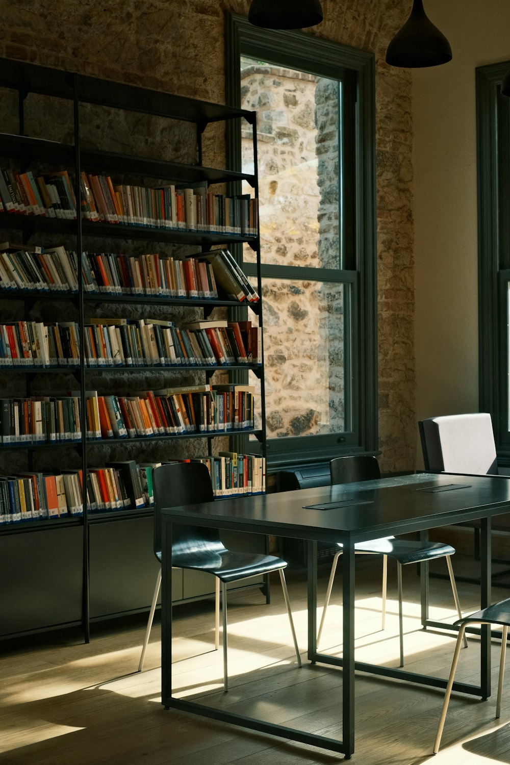 a table and chairs in a room with a book shelf