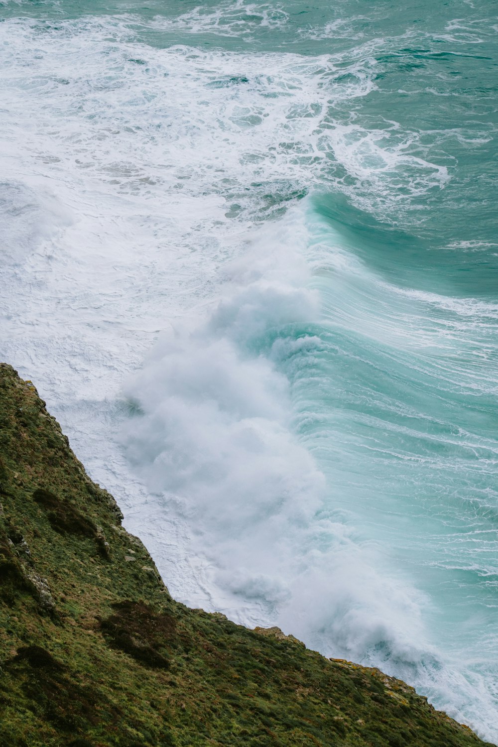 a person standing on a cliff looking at the ocean