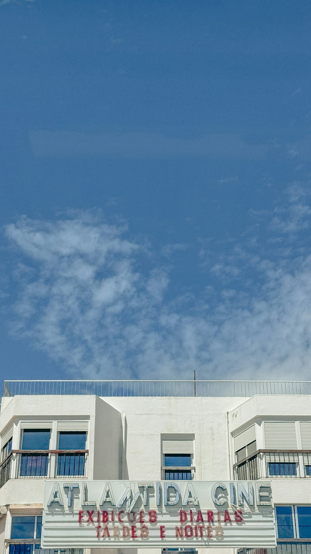 a tall white building with a clock on it's side