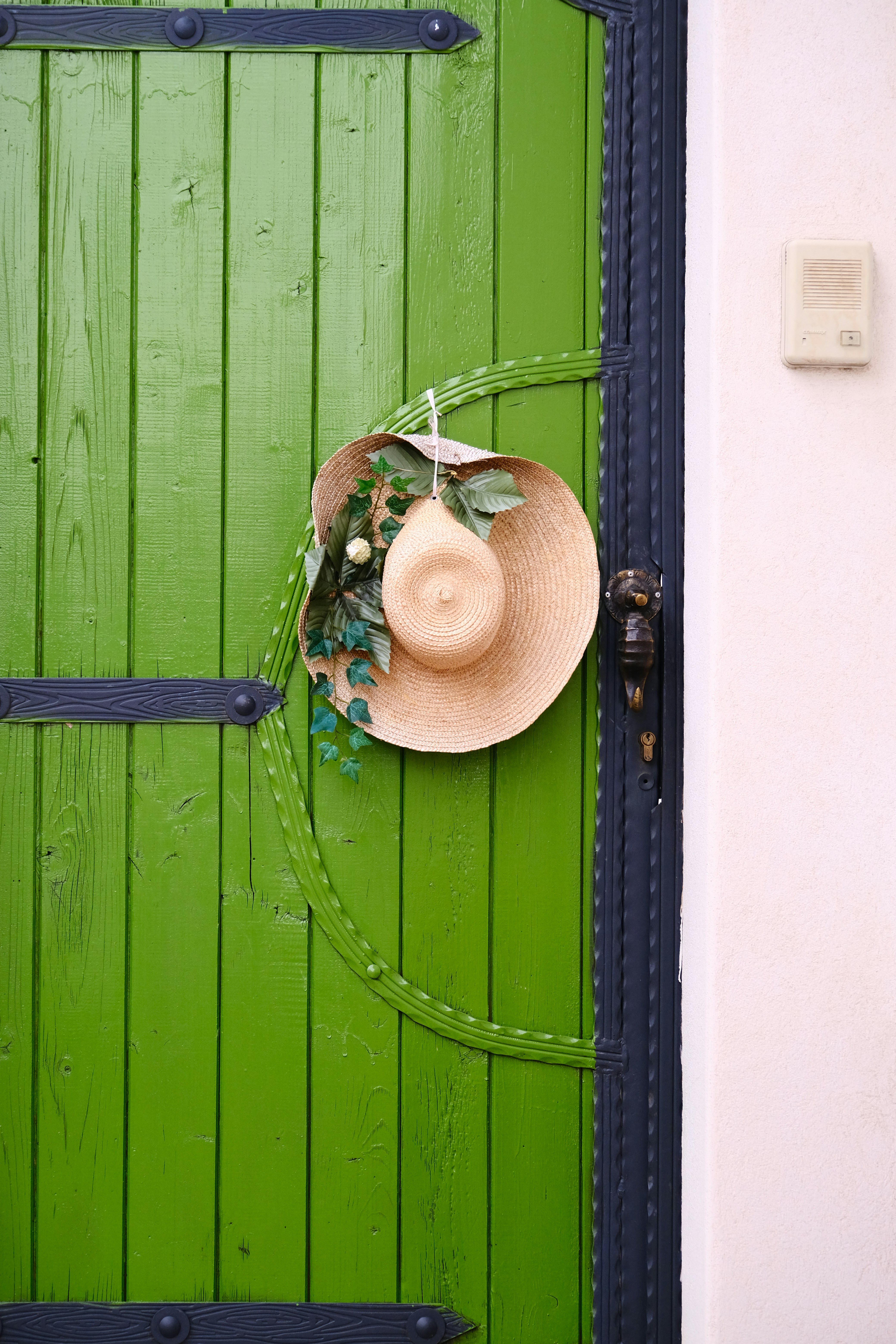 uma porta verde com um chapéu pendurado nela
