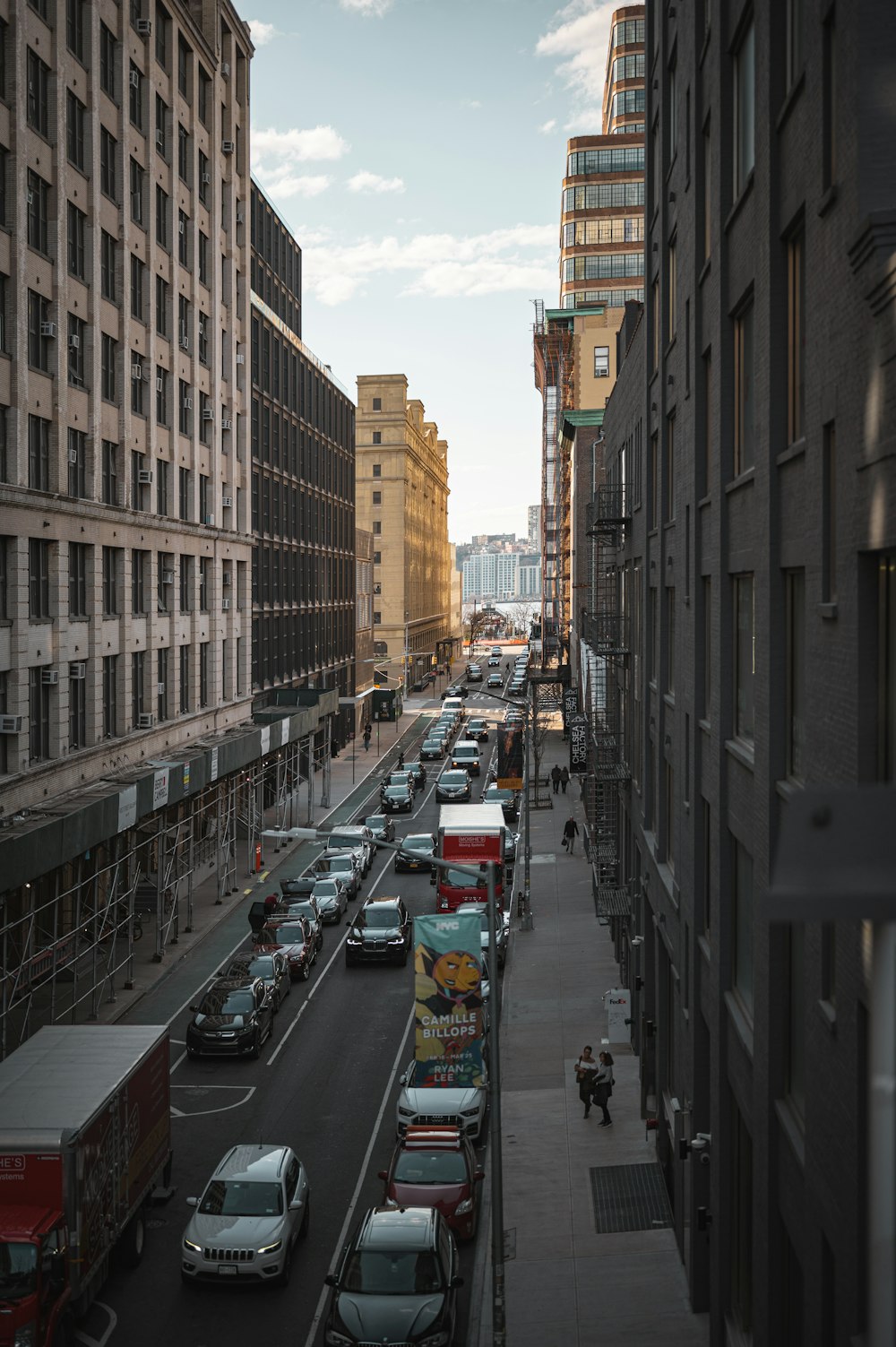 a city street filled with lots of traffic next to tall buildings