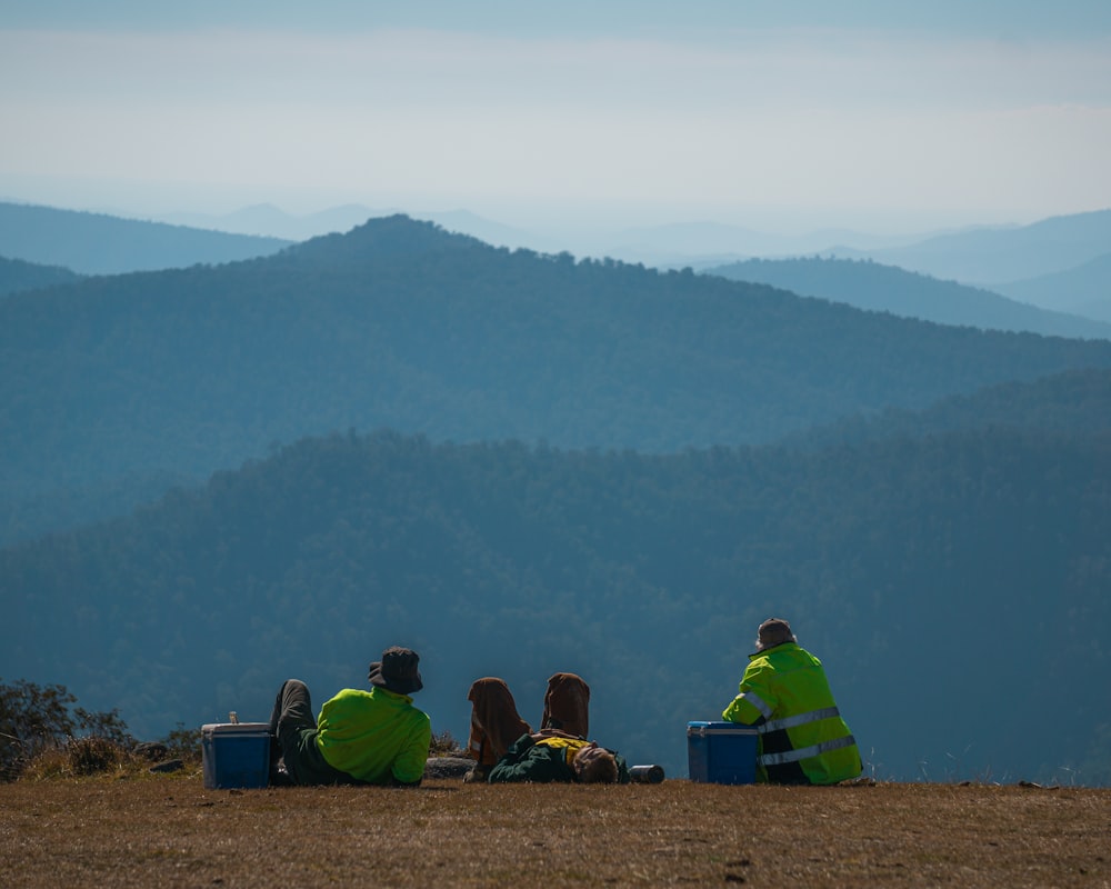 a couple of people sitting on top of a hill