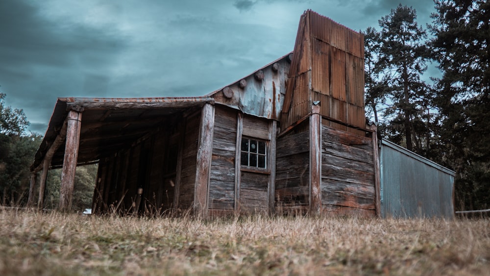 an old wooden building sitting in a field