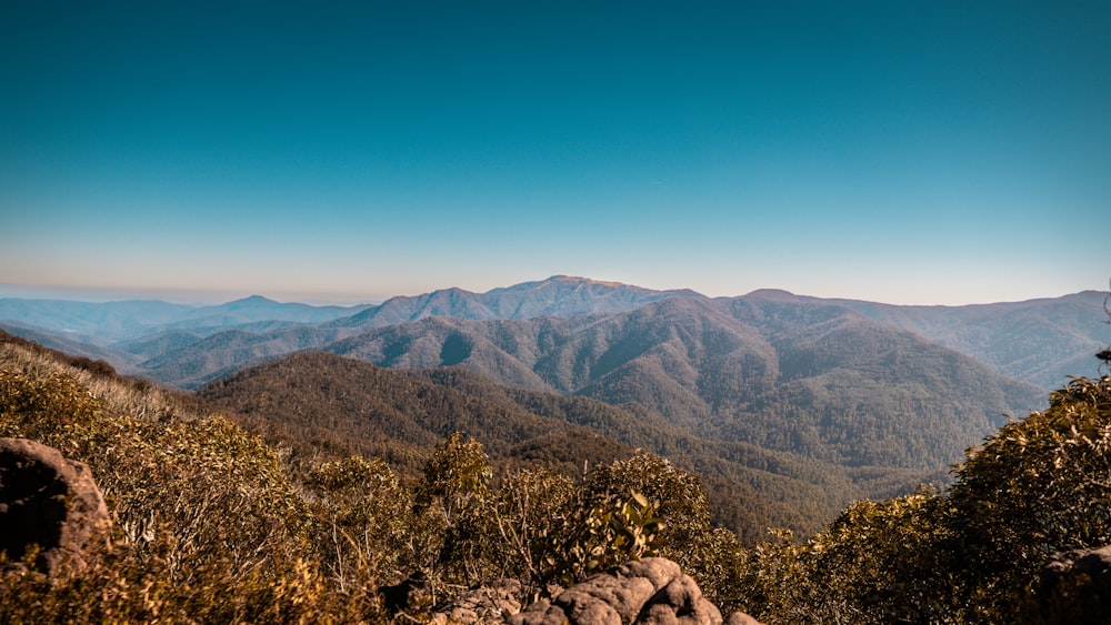 a view of a mountain range from the top of a hill