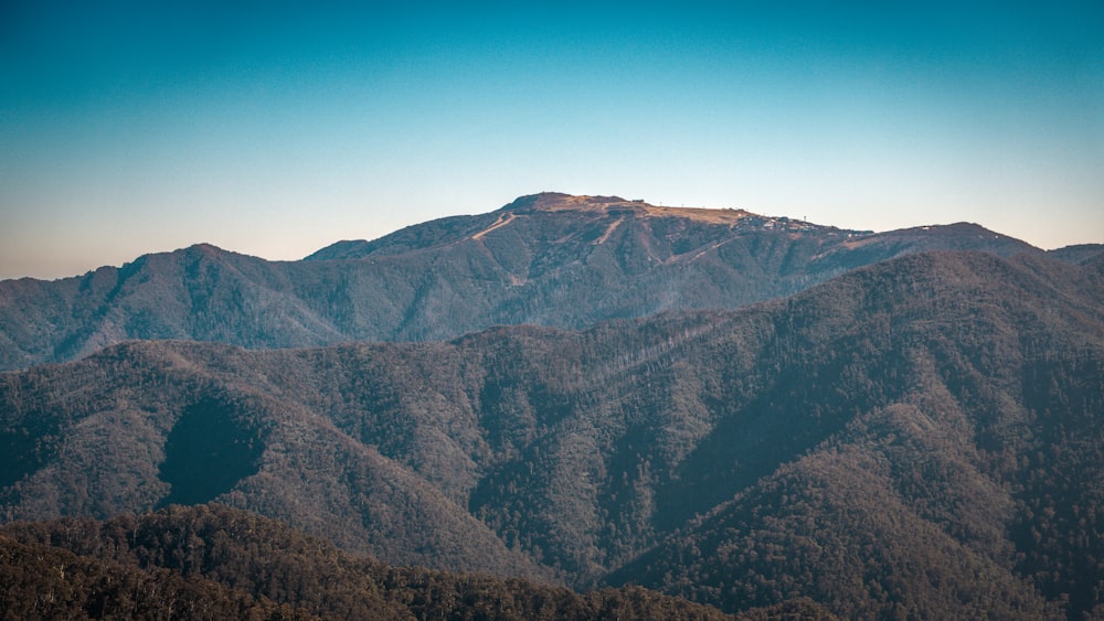 a view of a mountain range from the top of a hill