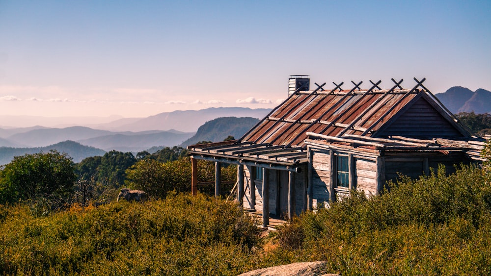 a small wooden cabin sitting on top of a lush green hillside