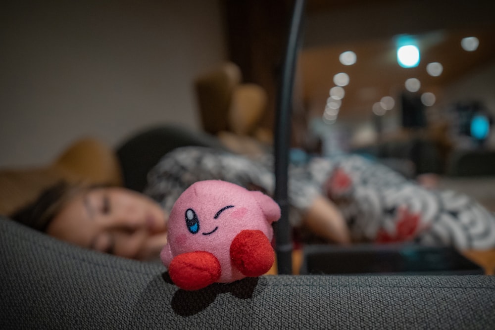 a pink stuffed animal laying on top of a couch