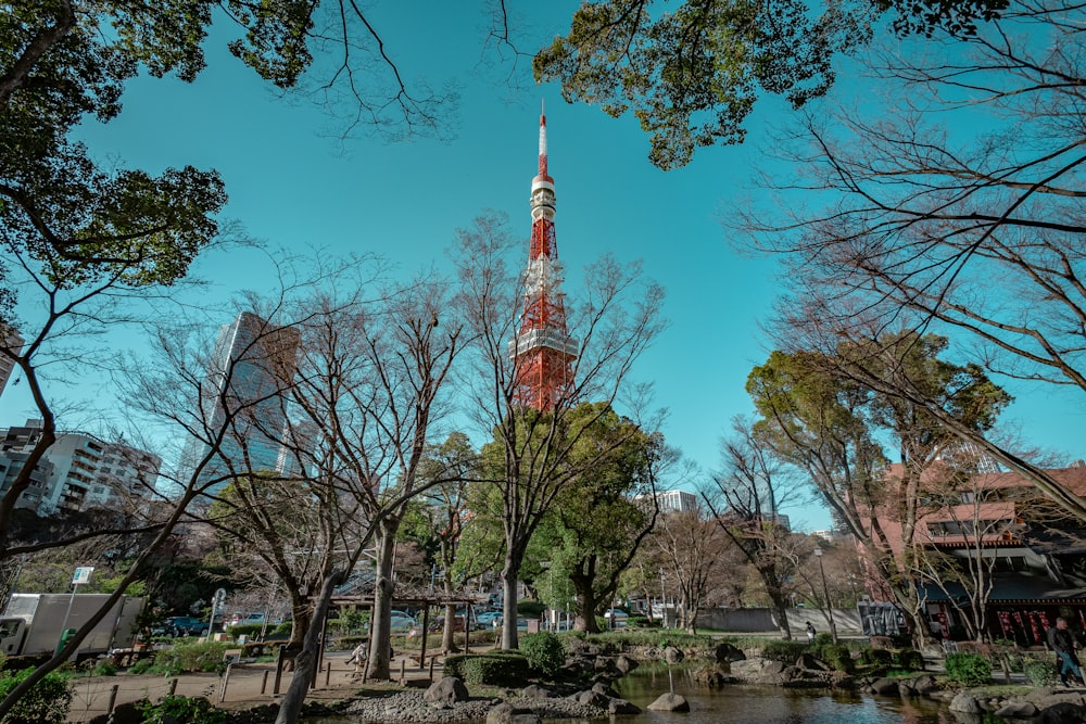a tall tower towering over a river surrounded by trees