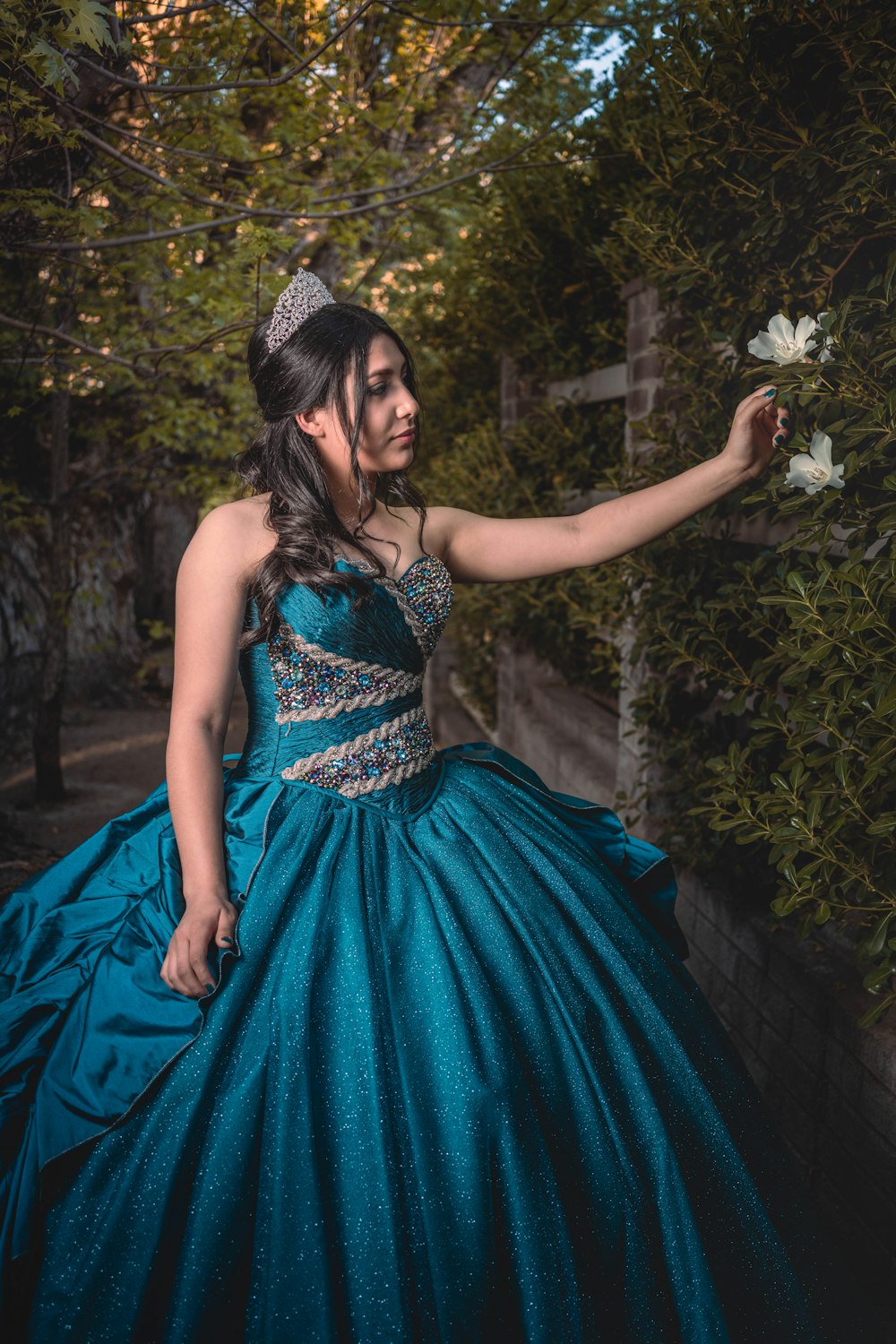 a woman in a blue dress holding a flower