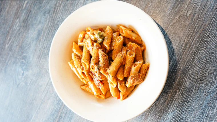 Bowl de pasta sobre una mesa de madera