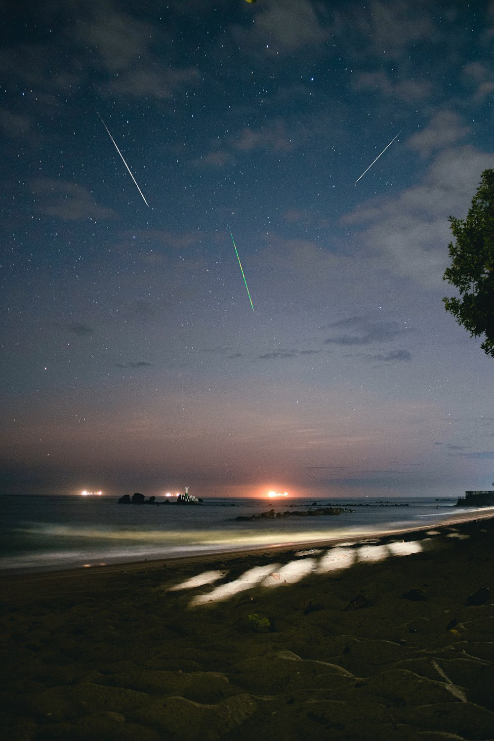 a view of a beach at night with the stars in the sky