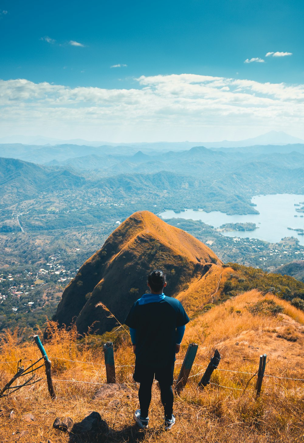 a man standing on top of a lush green hillside