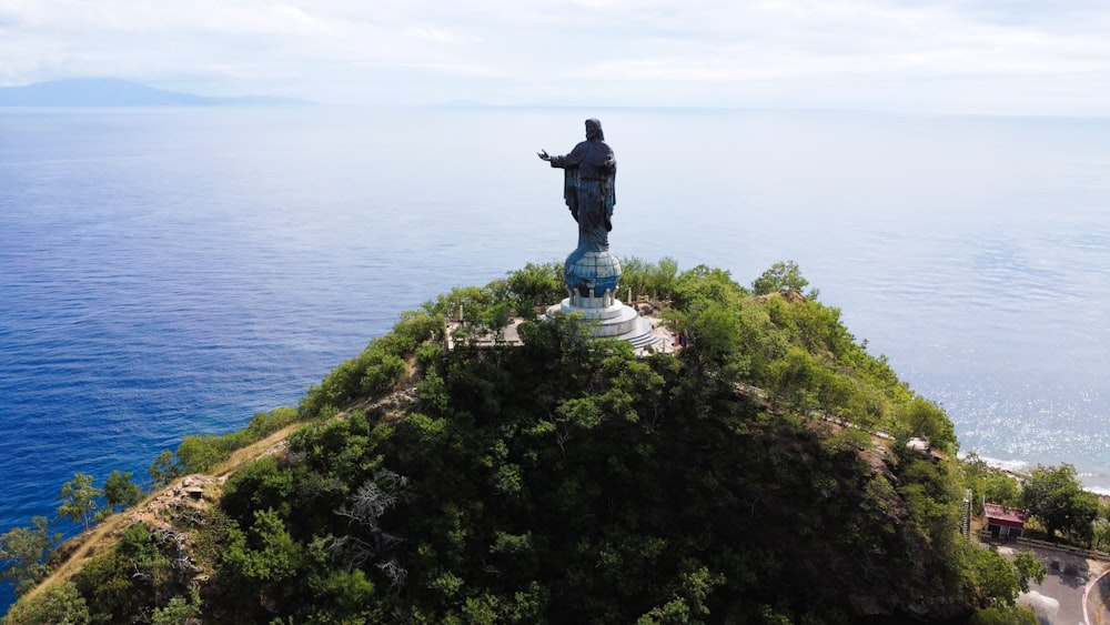 a statue of a man standing on top of a small island