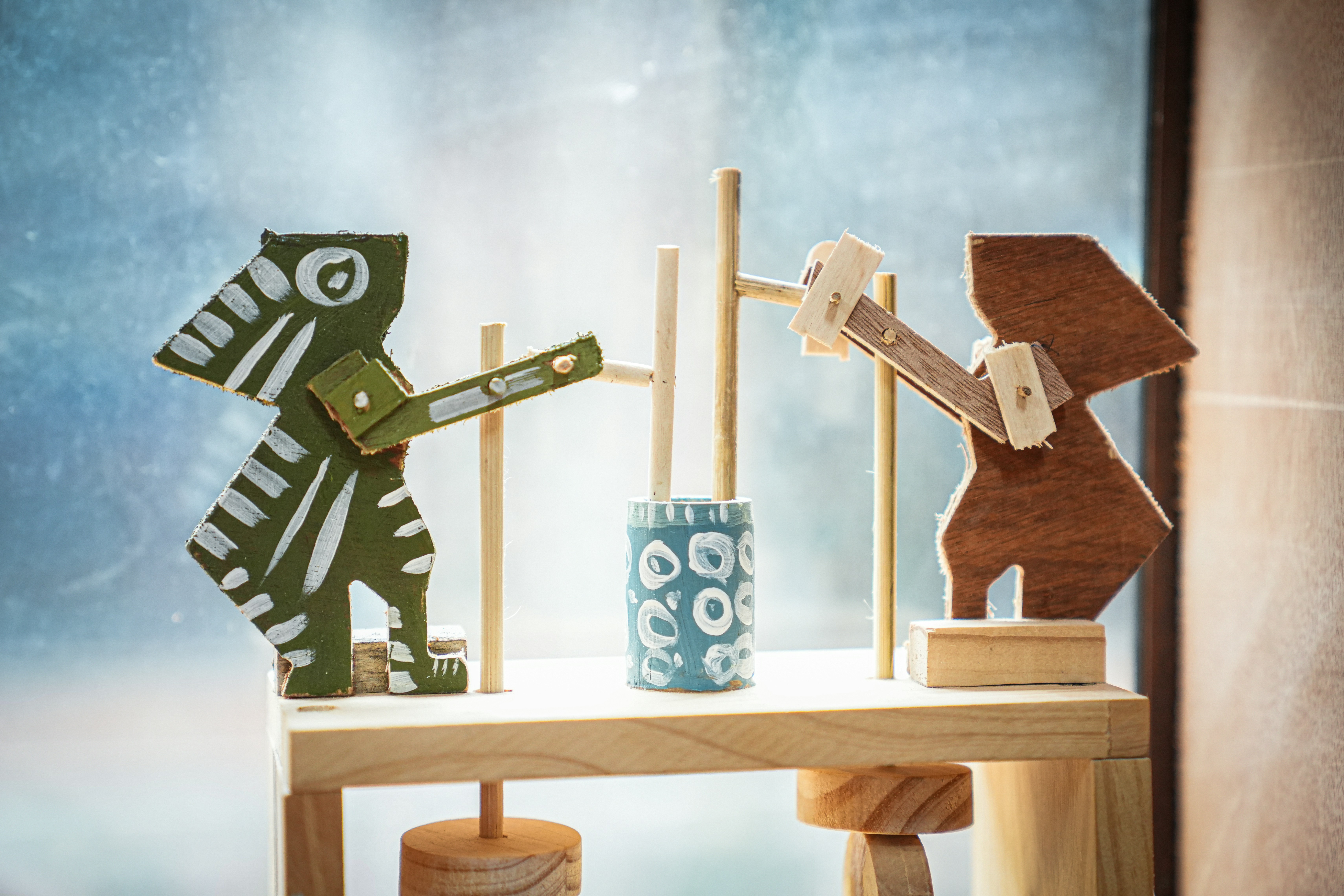a wooden table topped with wooden toy animals