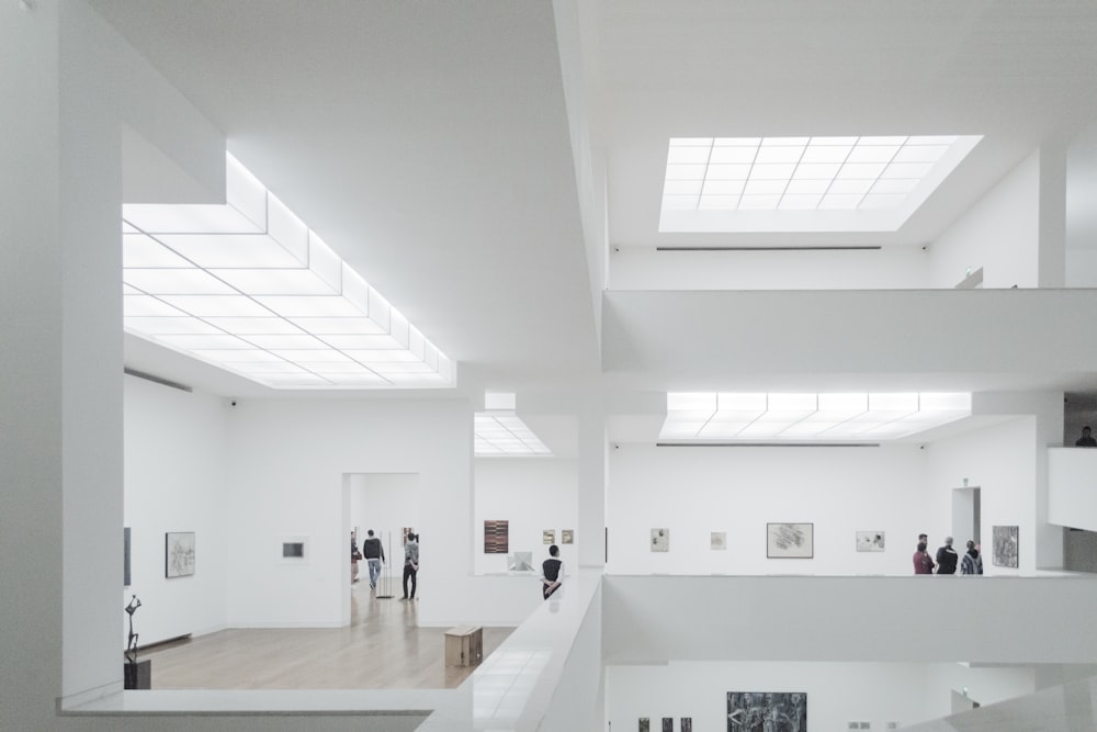 a group of people standing inside of a white building