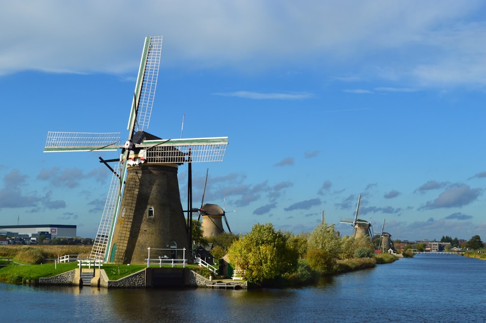 a windmill sitting on the side of a river