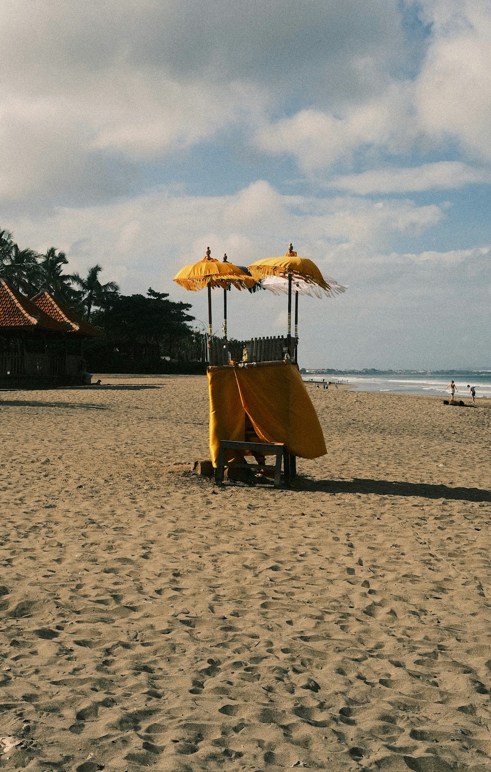 a yellow cart sitting on top of a sandy beach