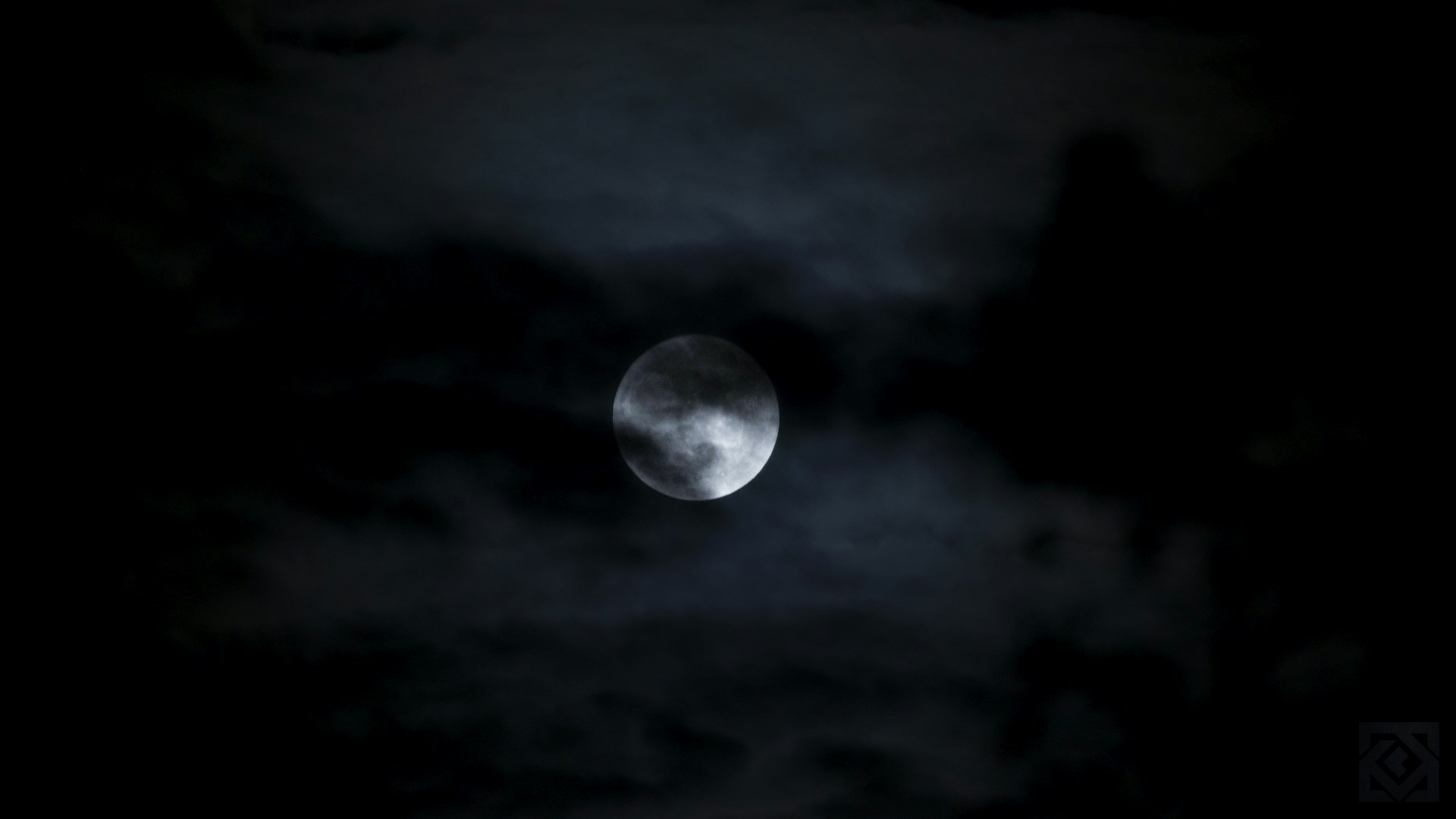 a full moon is seen through the clouds