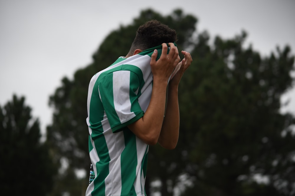 a soccer player covers his face with his hands
