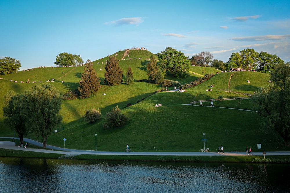 a grassy hill with a lake in front of it