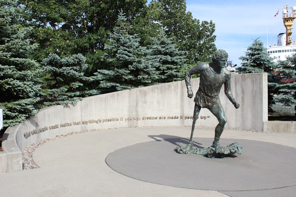 a statue of a man holding a stick