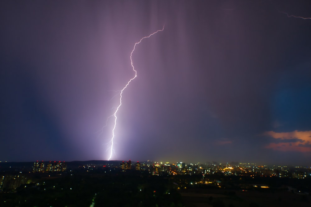 a lightning bolt hitting over a city at night