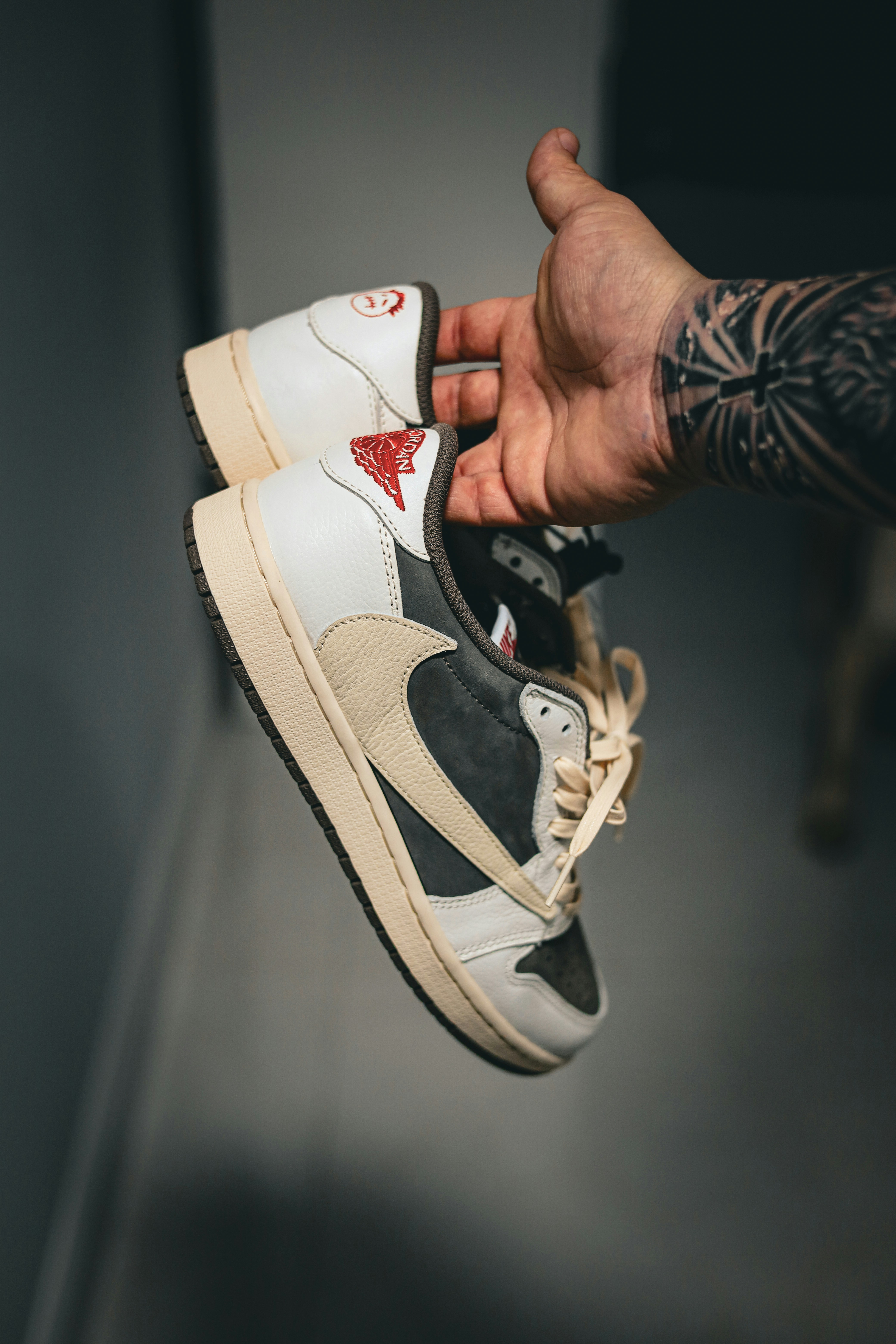 a person holding a pair of sneakers in their hand