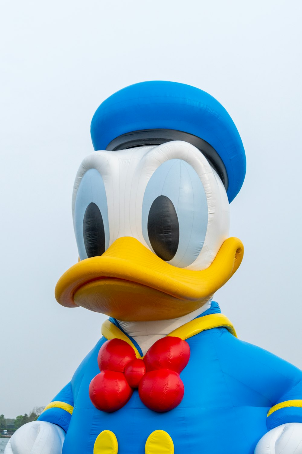 a large duck in a blue suit with a red bow