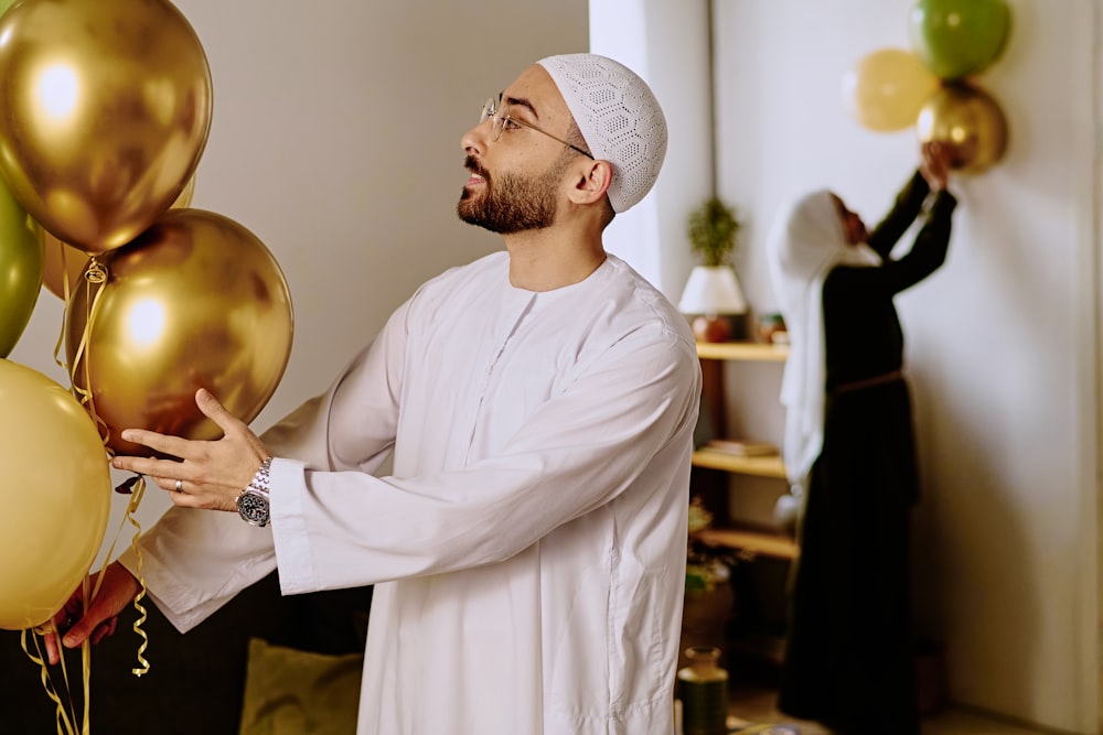 a man holding a bunch of balloons in his hands