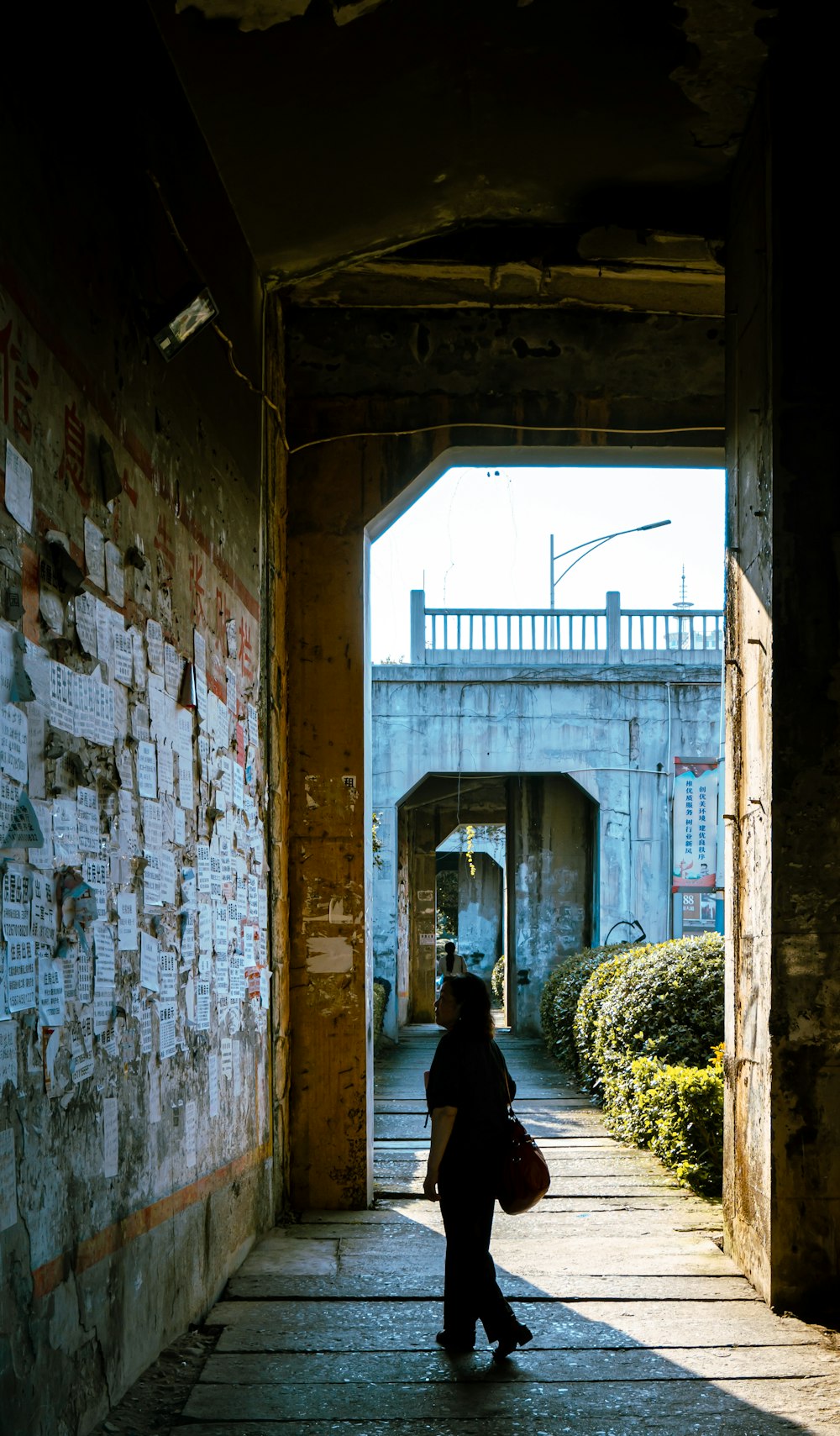 a person walking down a walkway in a tunnel