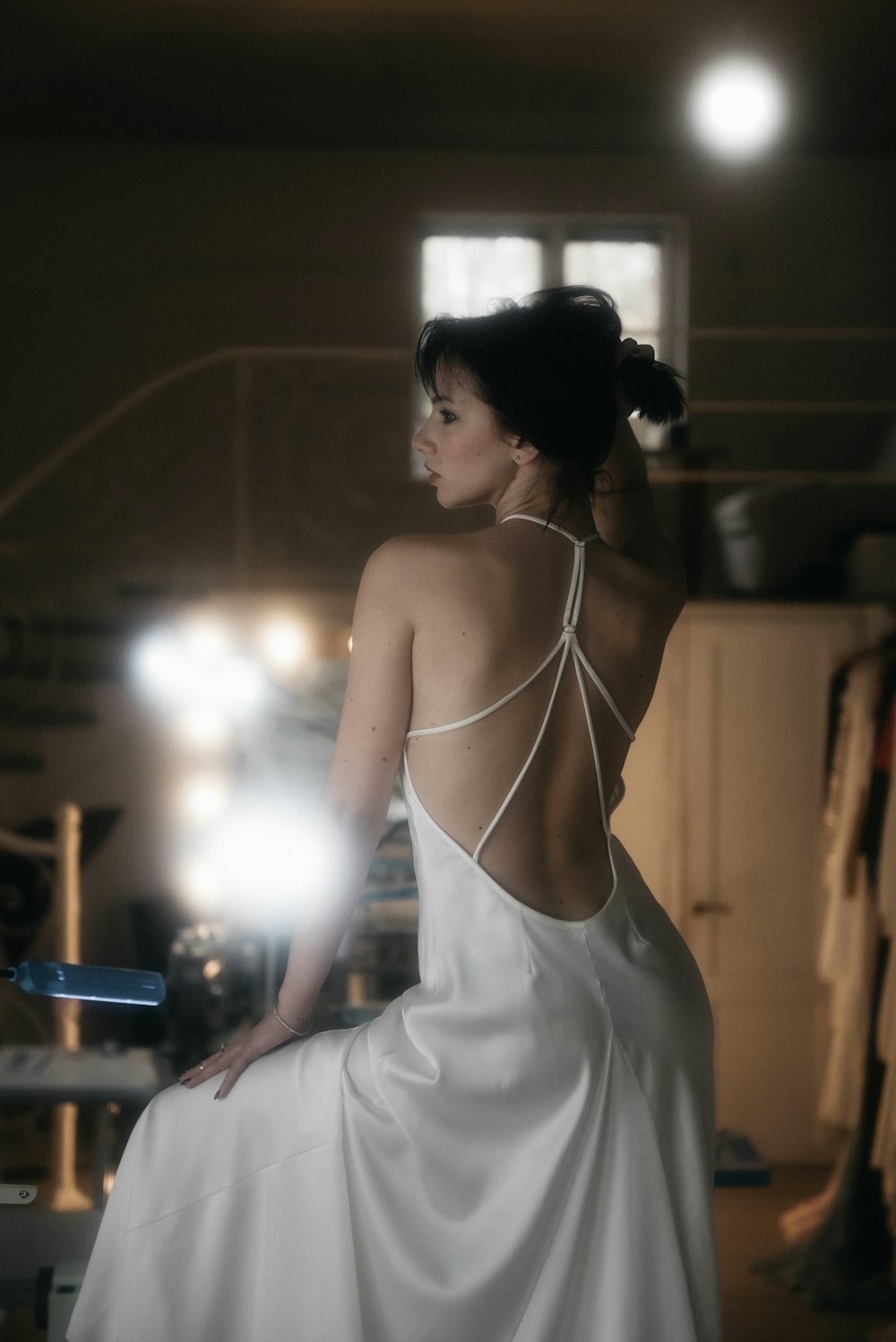 a woman in a white dress standing in a room