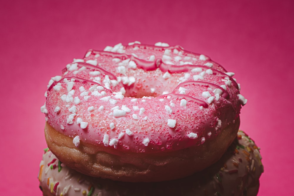 three donuts with pink frosting and sprinkles
