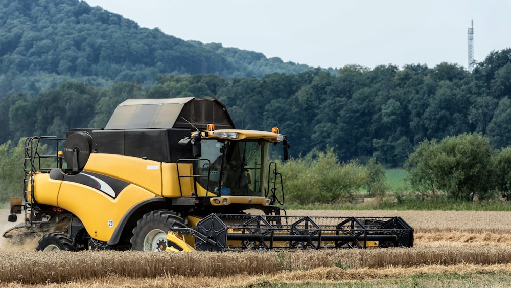 a yellow tractor is driving through a field