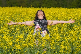 a woman standing in a field of yellow flowers was ist glück