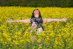 a woman standing in a field of yellow flowers