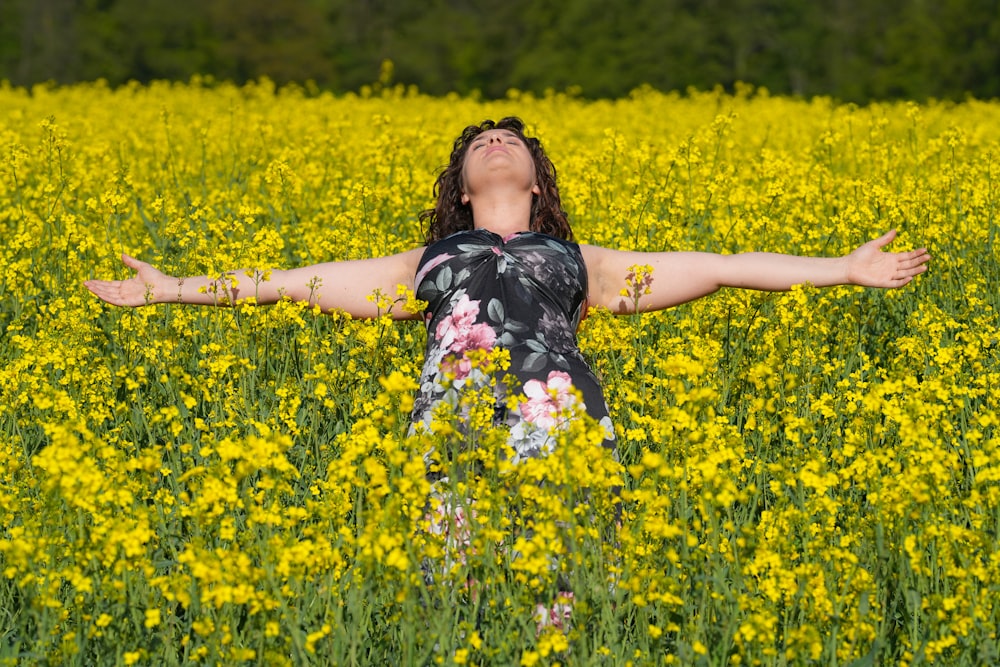 a woman standing in a field of yellow flowers