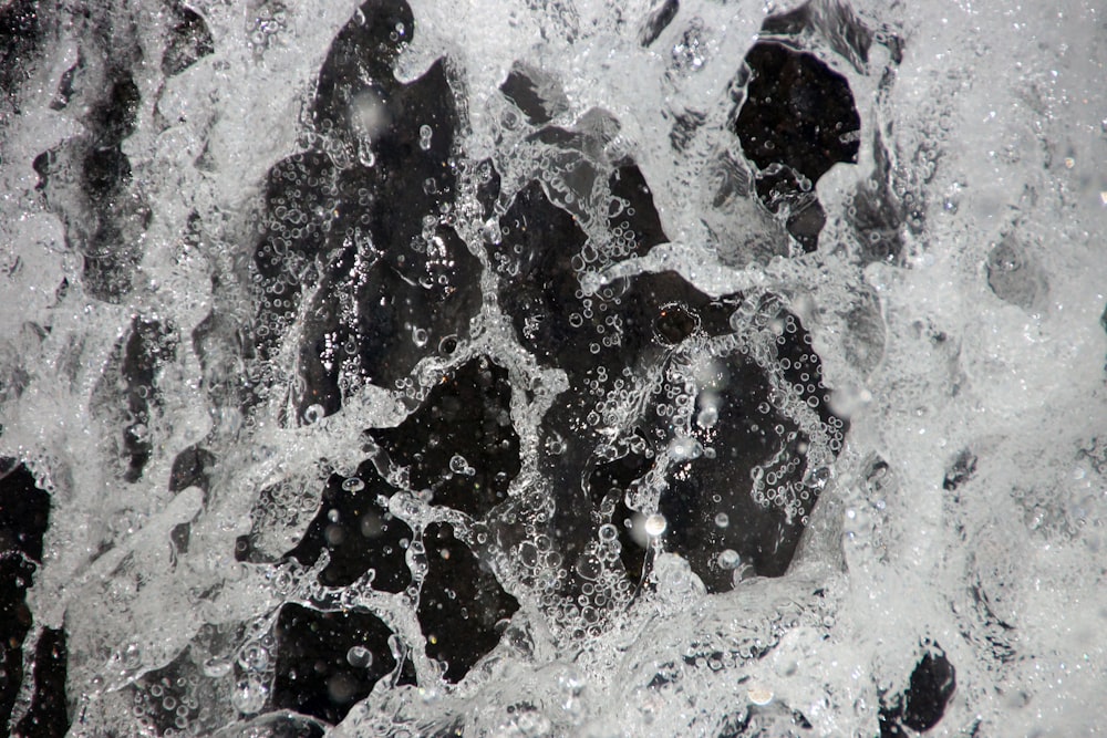 a close up of water splashing on rocks