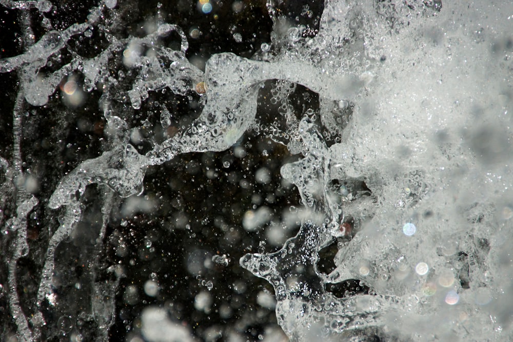 a close up of water splashing on a black background