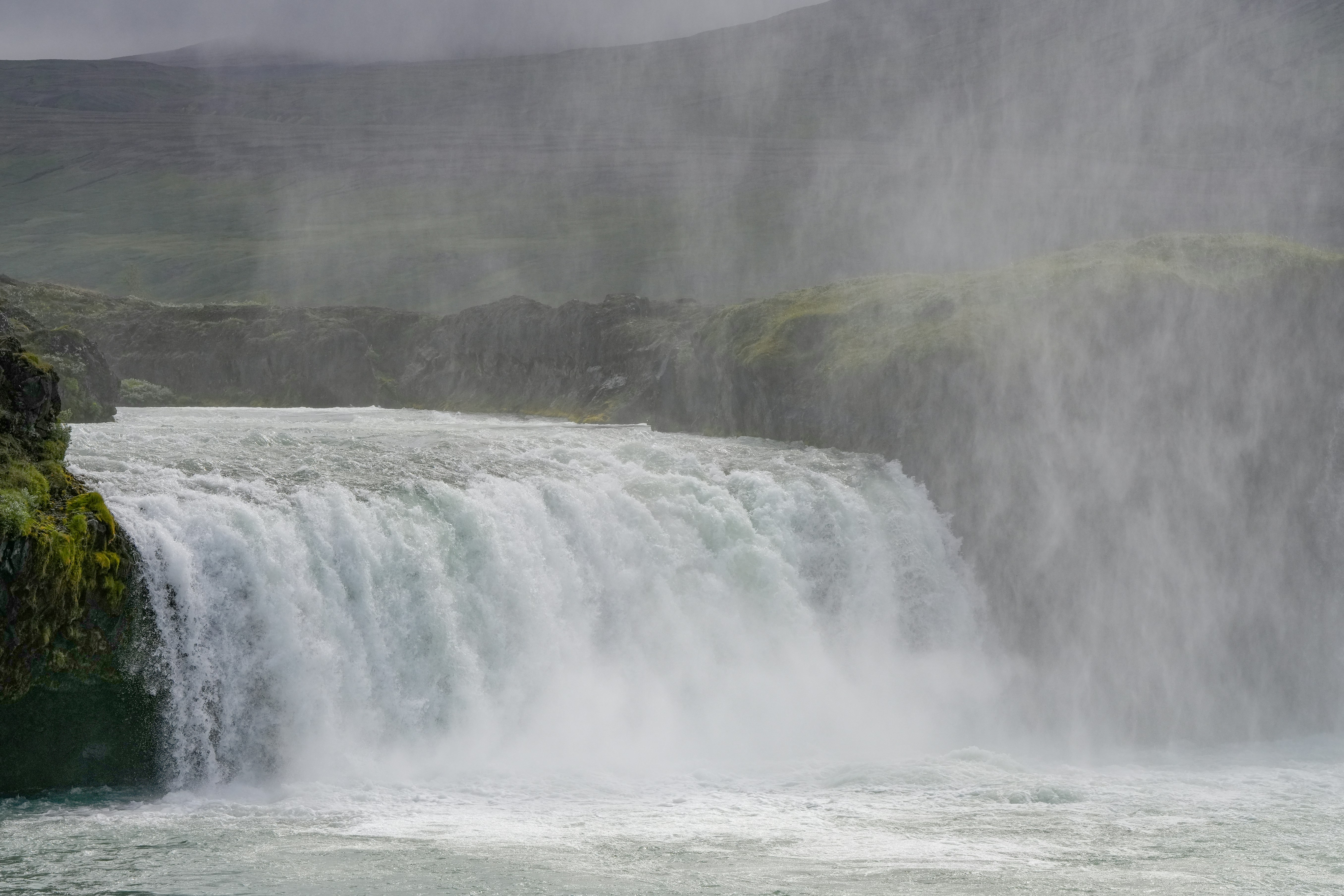 a large waterfall with water pouring out of it, 