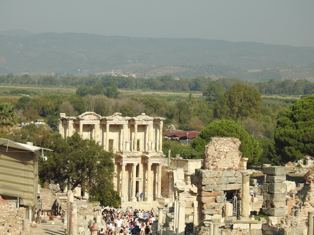 a crowd of people walking around a stone building