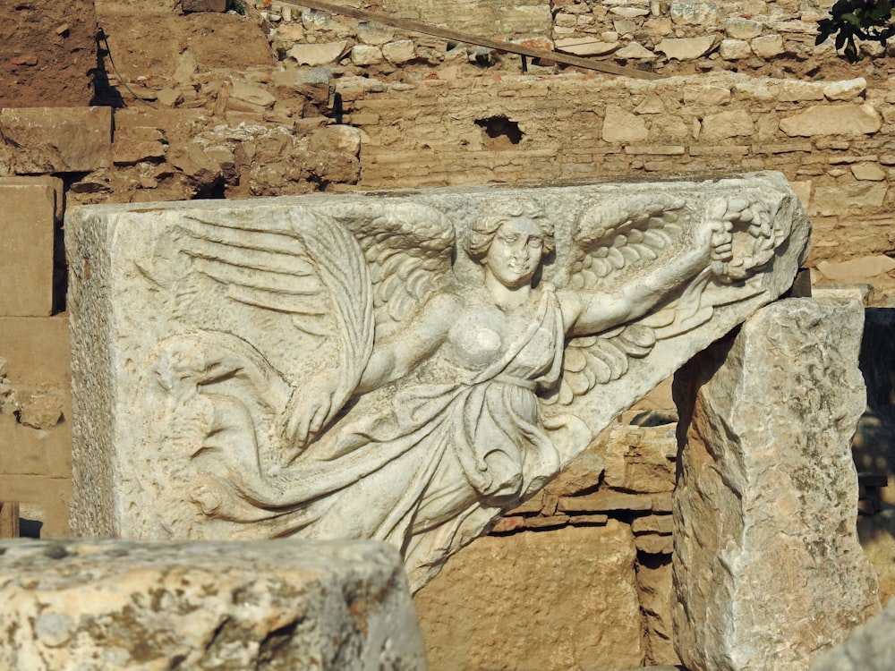 a close up of a statue on a stone wall