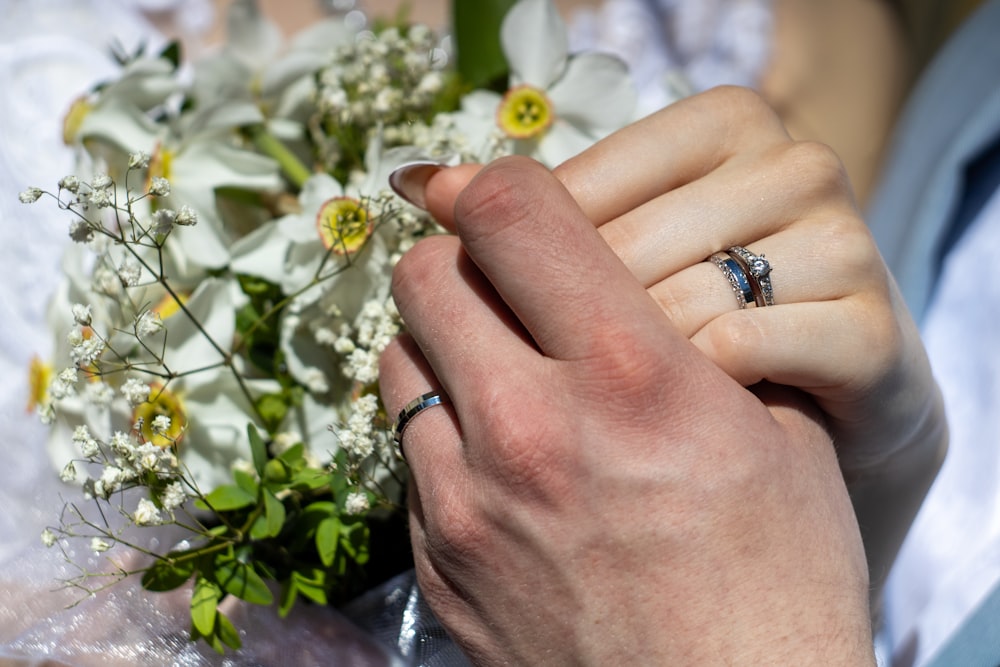 a close up of a person holding a bouquet of flowers