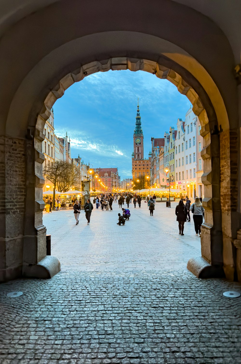 a group of people walking down a cobblestone street