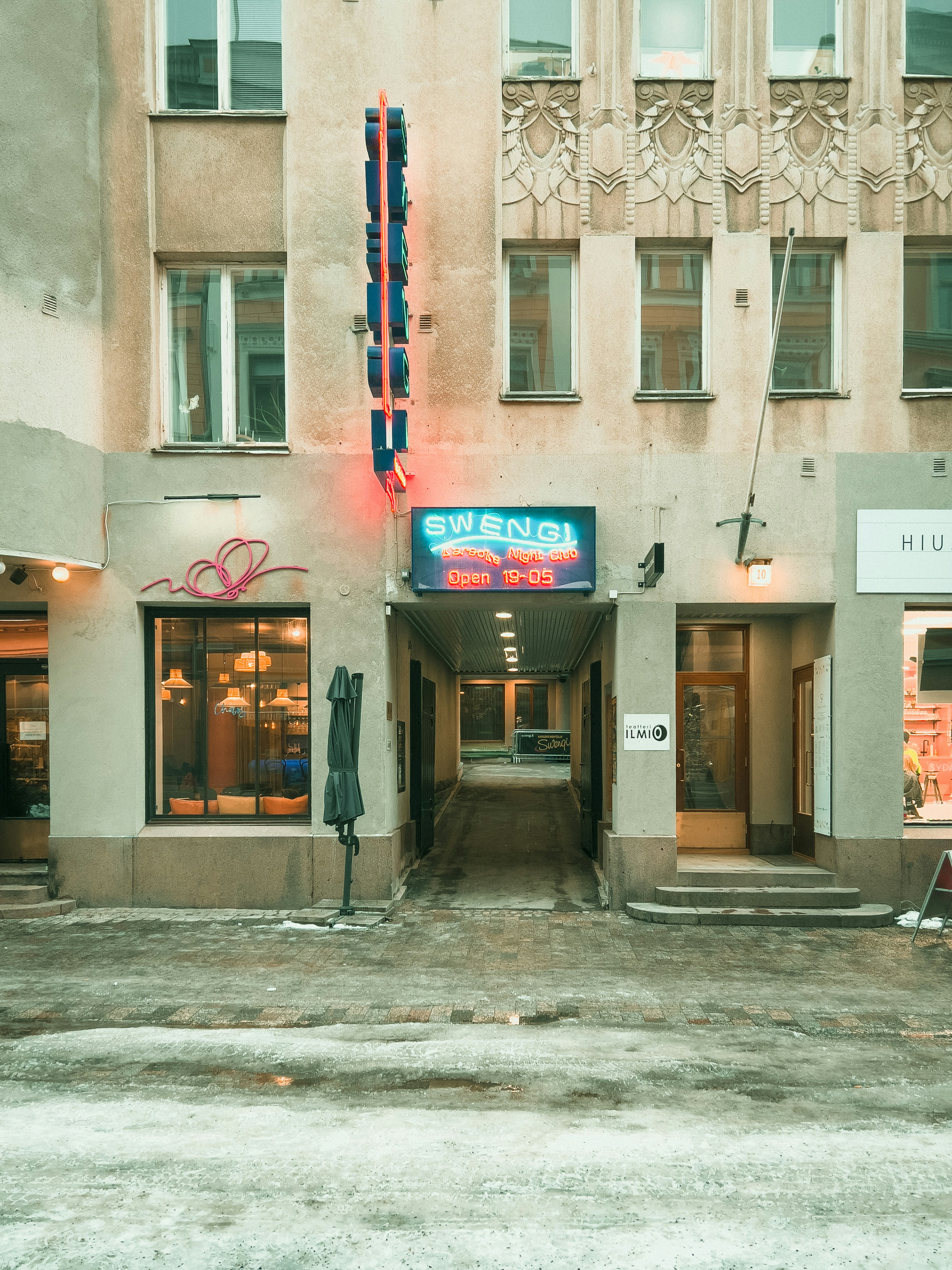 a tall building with a neon sign in front of it