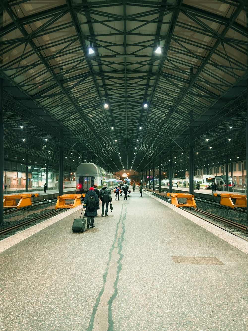 a train station with people and a train on the tracks