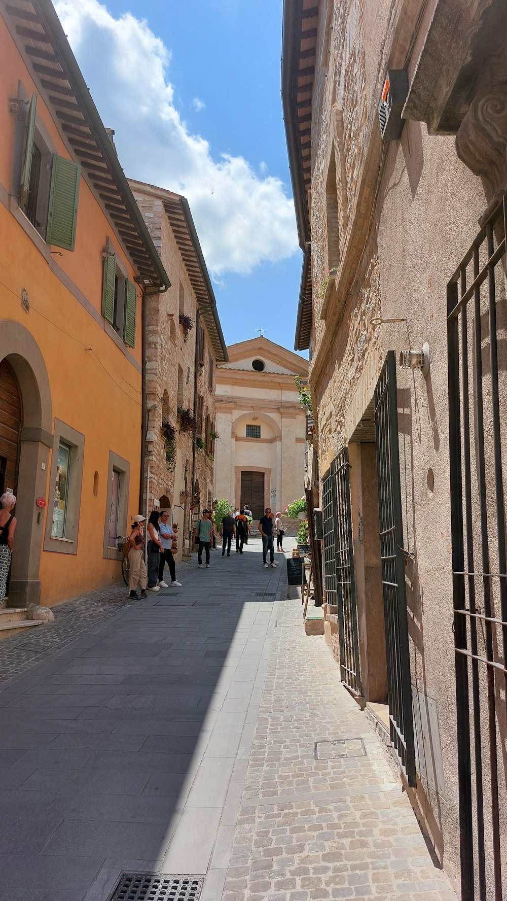 a narrow street with people walking down it