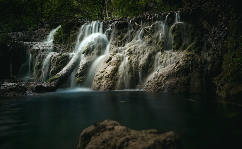 a small waterfall in the middle of a forest