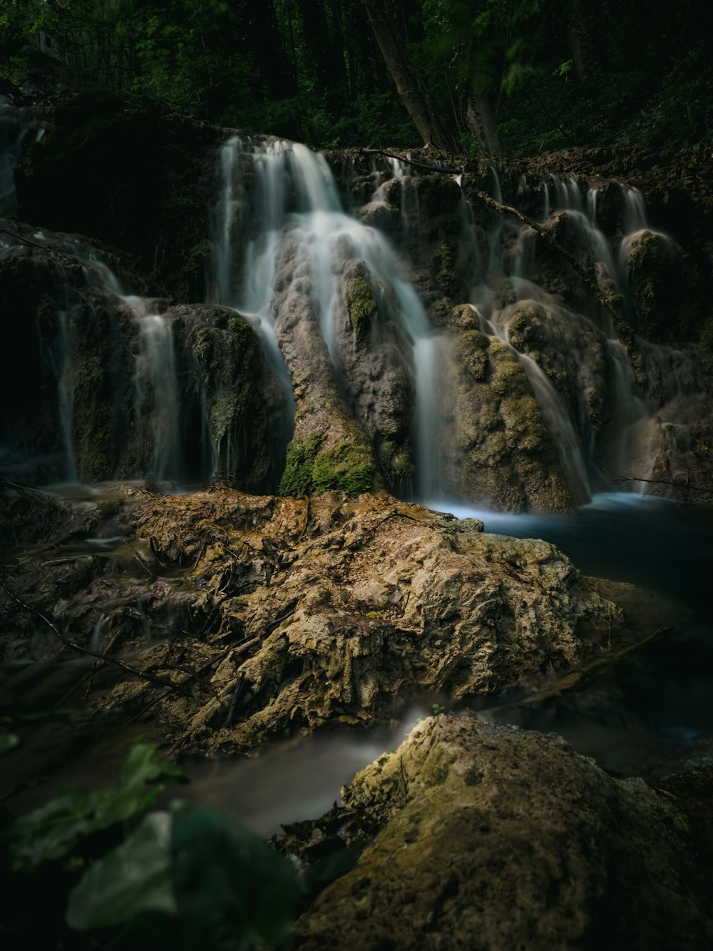 a small waterfall in the middle of a forest